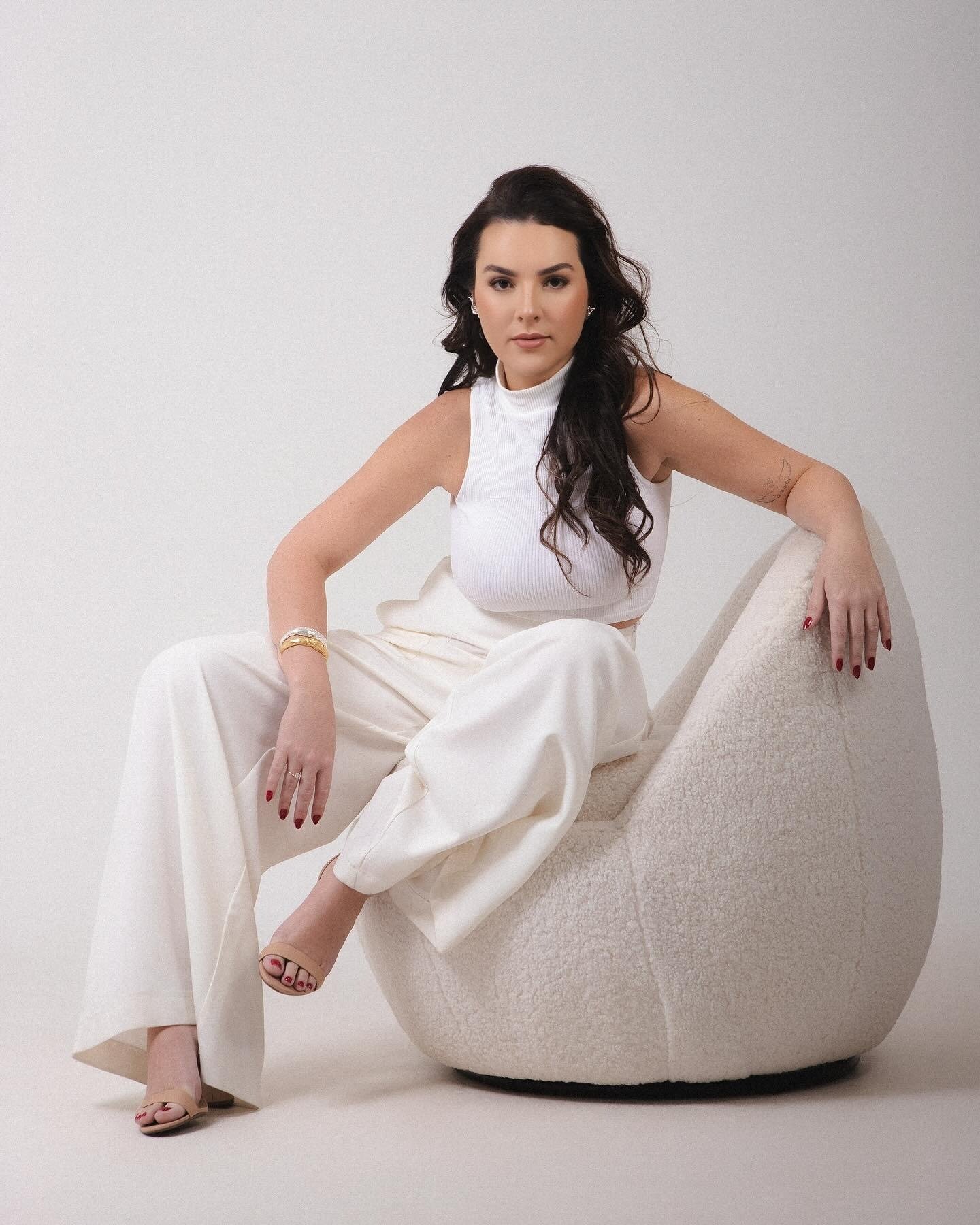 Retrato da profissional sentada, com roupa clara